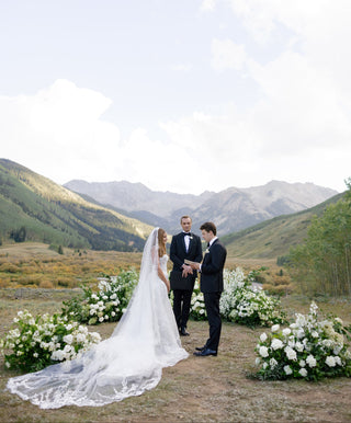 Wedding couple standing in a scenic mountain setting with florals arrangements in Aspen, Colorado.